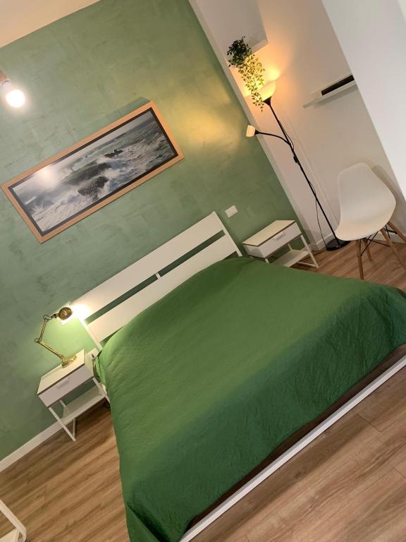 zielone łóżko w pokoju z zieloną ścianą w obiekcie Lemontreeqse w mieście Quartu SantʼElena