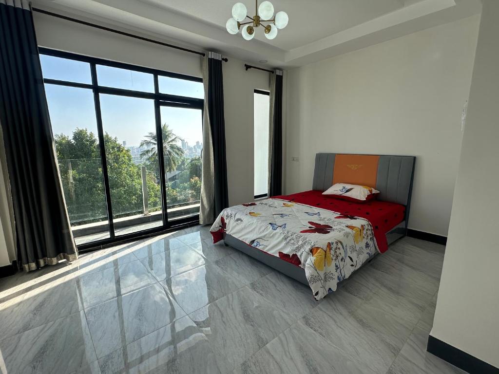 um quarto com uma cama e uma grande janela em Peaceful Homestay em Sihanoukville