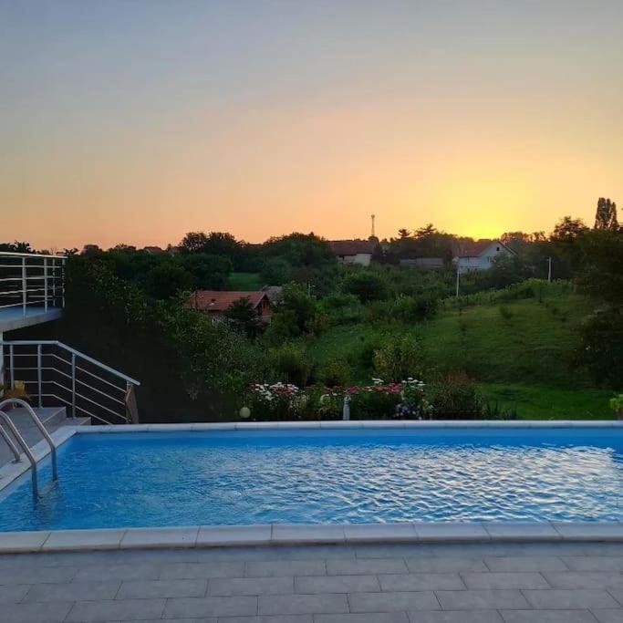 a large blue swimming pool with a sunset in the background at BigNest in Smederevo