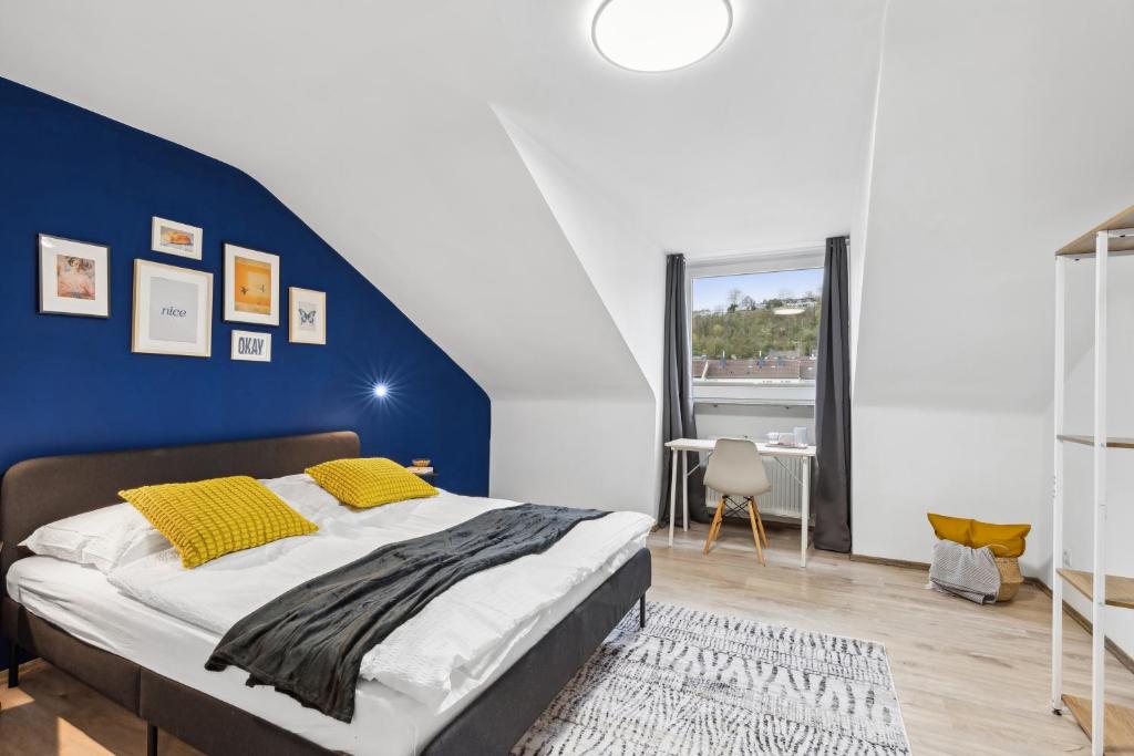Un dormitorio con una pared de acento azul y una cama en Zentrale, Große & Moderne Unterkunft in Koblenz en Koblenz