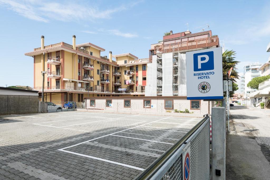 a parking lot with a parking sign in front of a building at Hotel Marco Polo in Lido di Jesolo