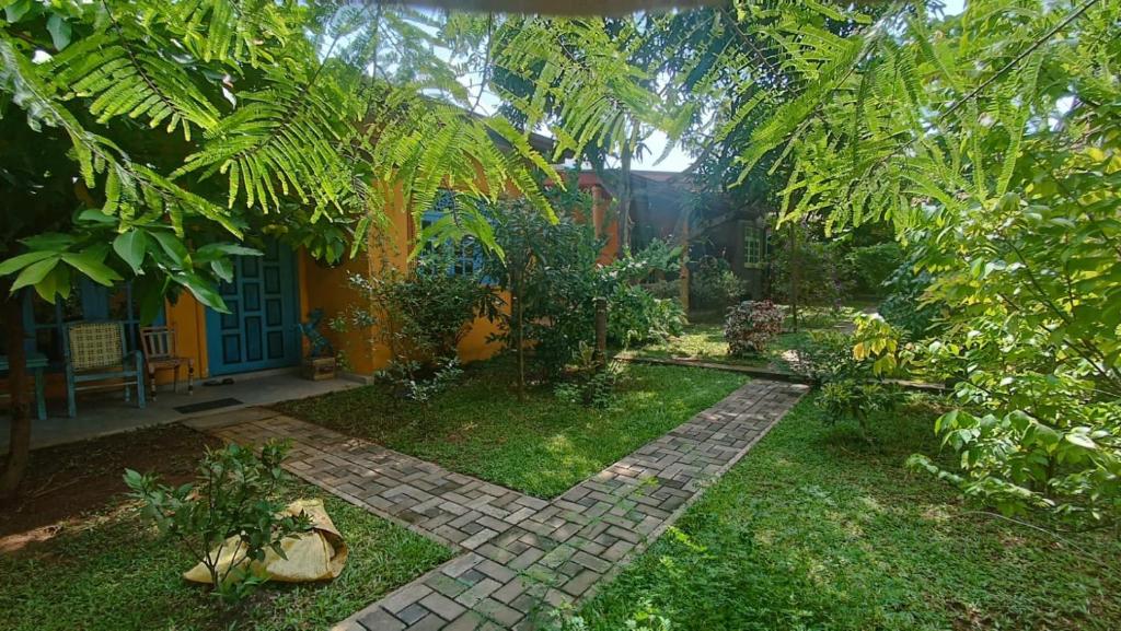 Dhee Ayurveda Villa في Malabe: حديقة بها مسار من الطوب أمام المنزل