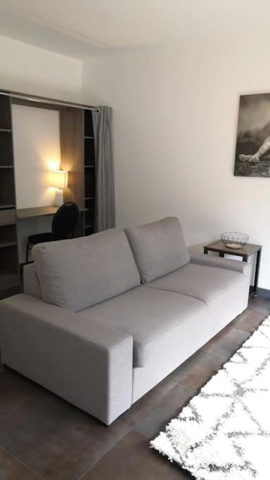 een witte bank in een woonkamer met een tafel bij Grand T1 très calme Proche centre ville Rodez in Rodez