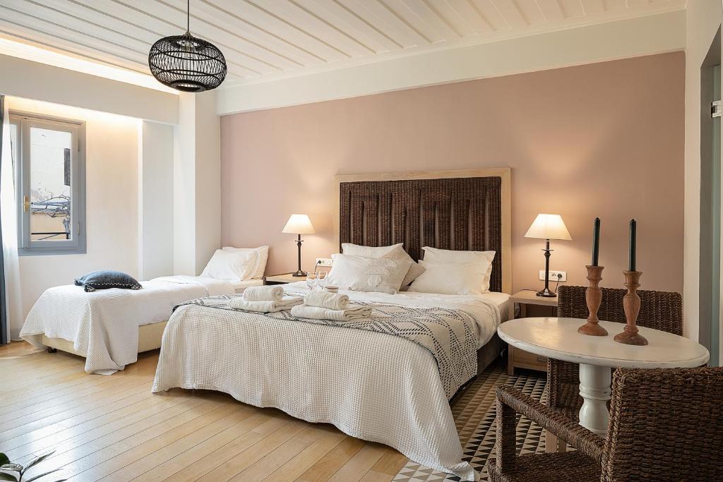 a hotel room with two beds and a table at Vranas Ambiance Hotel in Chania