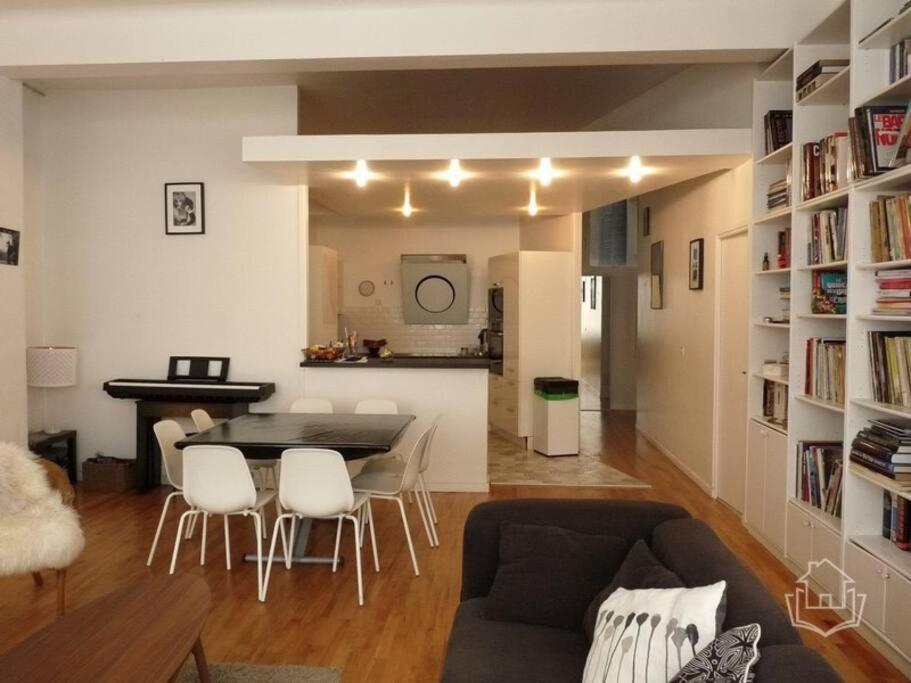 un salon avec une table et des chaises dans une pièce dans l'établissement Loft très calme centre de Paris, à Paris