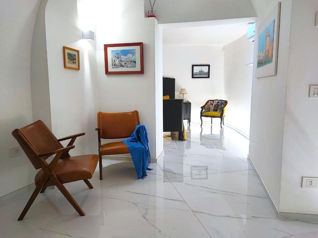 a living room with two chairs and a table at LianHome b&b "Volte" in Lucera