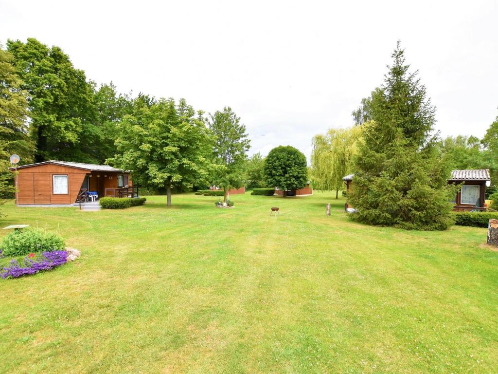 a large yard with a cabin and a house at Boutique Bungalow in Insel Poel with terrace in Insel Poel