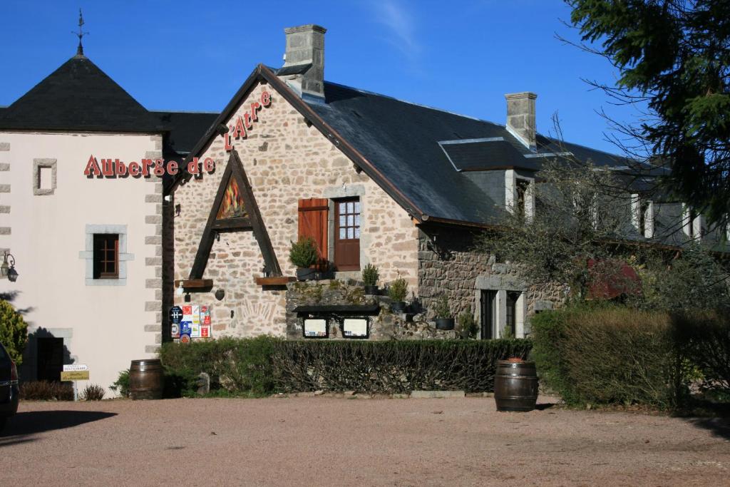 un bâtiment en pierre avec un panneau sur son côté dans l'établissement Auberge De L'Atre, à Quarré-les-Tombes