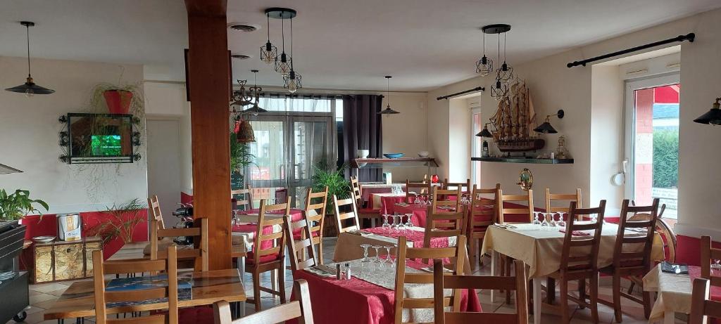 un restaurante con mesas y sillas en una habitación en Cap'tain Cook, en Caurel