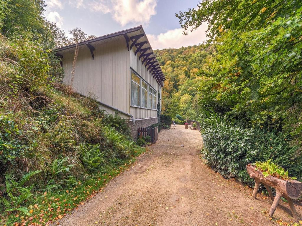 uma estrada de terra ao lado de um edifício e um banco em Rustic Apartment with Garden in Bad Harzburg Germany em Bad Harzburg