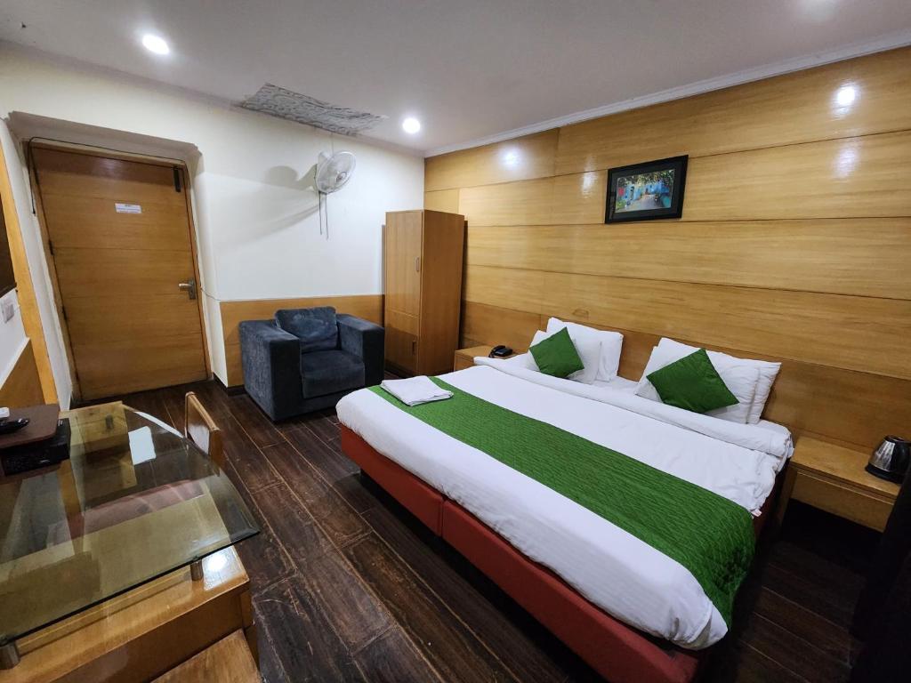 sypialnia z dużym łóżkiem i szklanym stołem w obiekcie Daffodils inn w Nowym Delhi