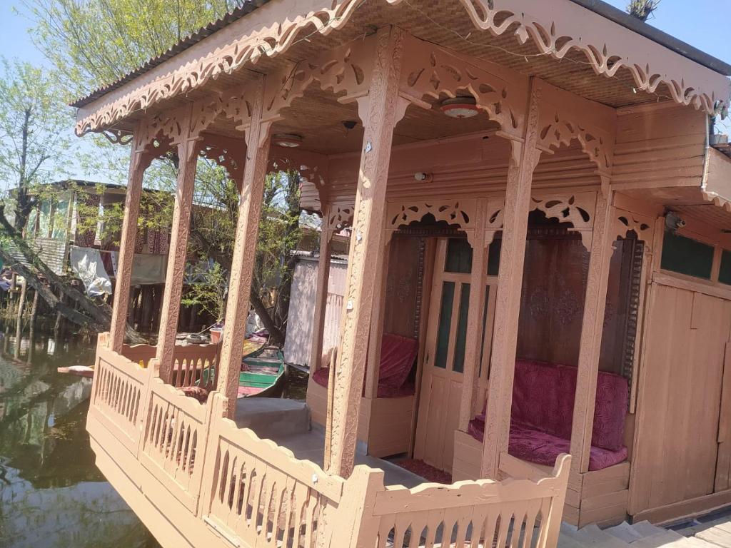 a wooden gazebo with a porch on the water at Young Lake Palace Group Of Houseboats in Srinagar