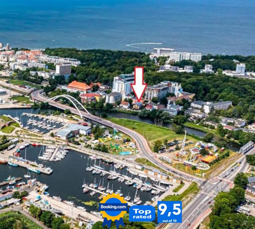 una ciudad con una flecha roja apuntando a un puerto deportivo en Villa Kapitańska en Kołobrzeg