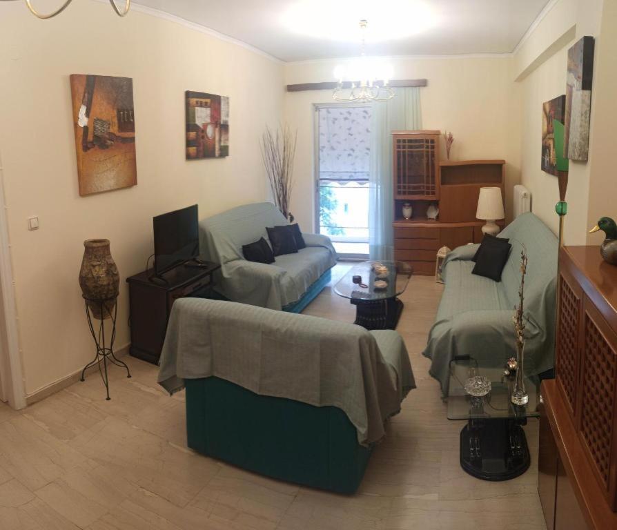 uma sala de estar com um sofá, uma cama e uma televisão em Comfortable apartment 200 m from the sea em Piraeus