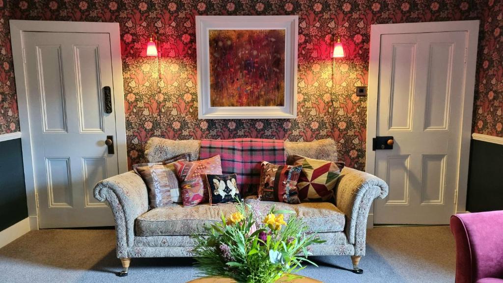 a living room with a couch with pillows at Luxury 3 Bedroom Cottage - Sleeps 6 in Tomintoul