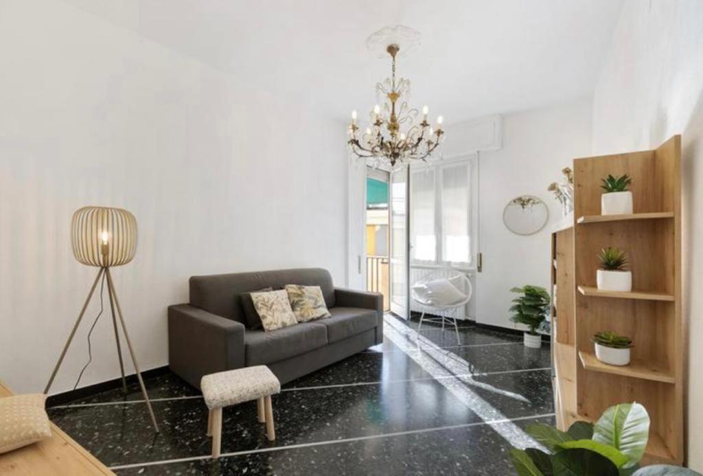 un soggiorno con divano e lampadario pendente di Cà Adri , appartamento in posizione strategica per godere delle spiaggia e dei sentieri Outdoor ! a Finale Ligure