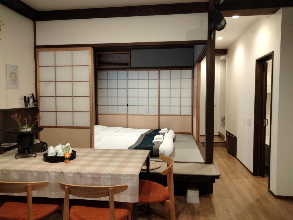 Habitación con cama, mesa y sillas. en 秋桜館Cosmos en Kioto