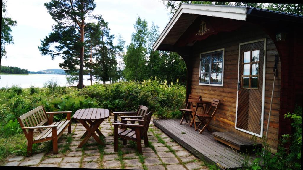 a cabin with a table and chairs on a deck at Mysigt boende på Brenäsudden in Insjön