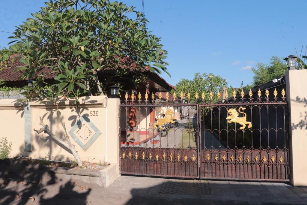 a fence with a gate in front of a house at Griya Mozaik in Jimbaran
