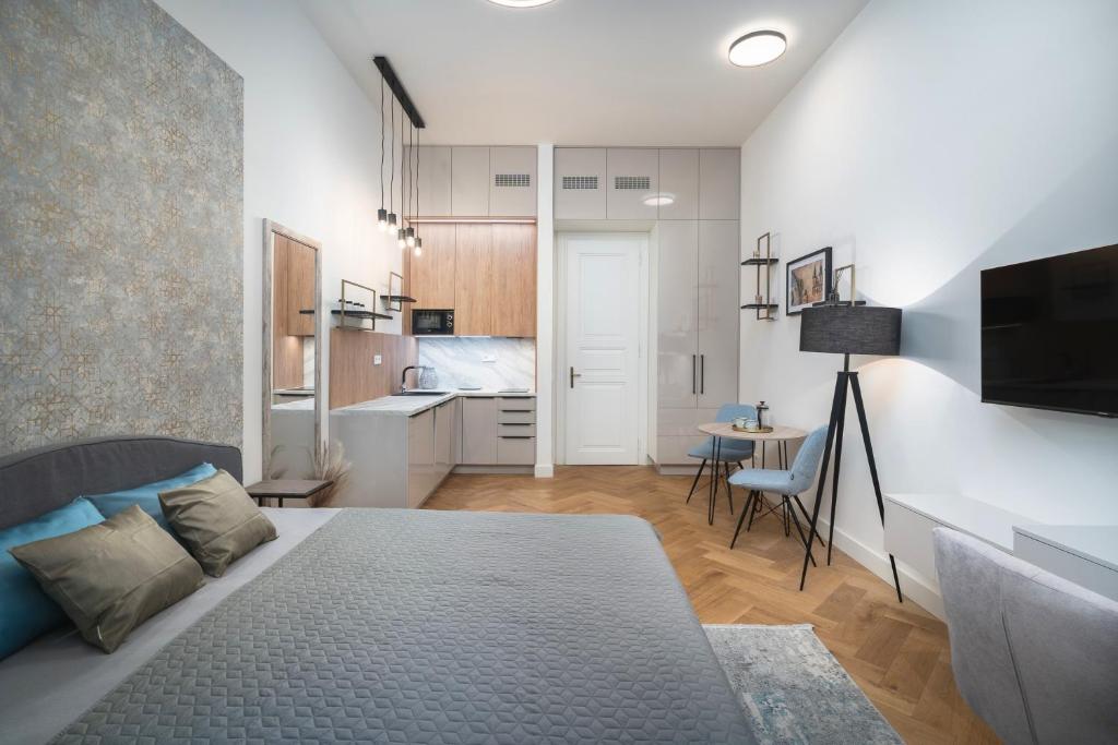 a large bedroom with a bed and a kitchen at Palace Dlazdena – Stylish Prague Centre Apartment in Prague