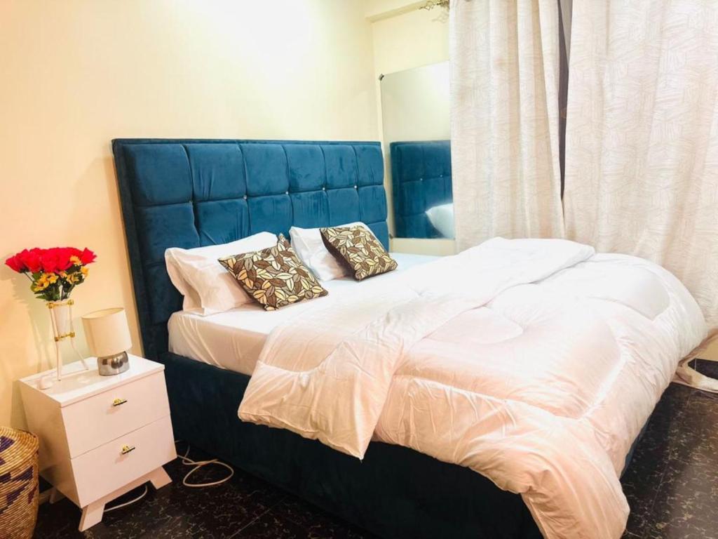 una camera con un grande letto con testiera blu di Downtown Dreamspace City - 3 bedrooms a Dar es Salaam
