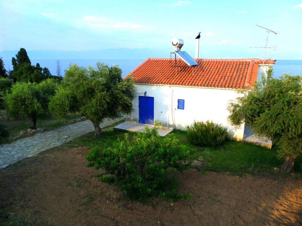 une maison blanche avec un toit rouge et une porte bleue dans l'établissement Tentes Holiday Homes, à Vounaria