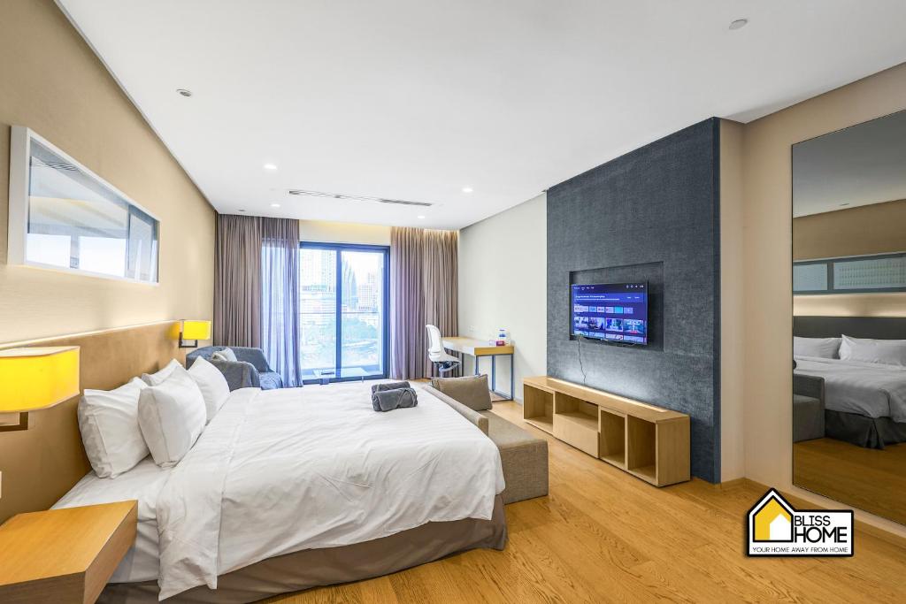 a hotel room with a bed and a tv at 188 Suites KLCC By Bliss Home At City Centre in Kuala Lumpur