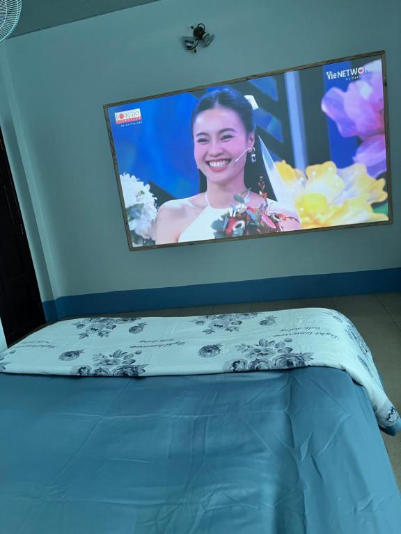 TV por encima de una cama en una habitación en MOCA MOTEL en Cao Lãnh