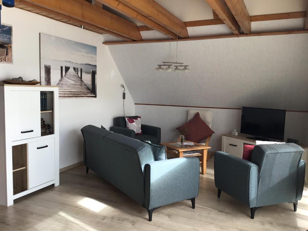 ein Wohnzimmer mit 2 Stühlen und einem TV in der Unterkunft Ferienwohnung Rosenweg in Rambin