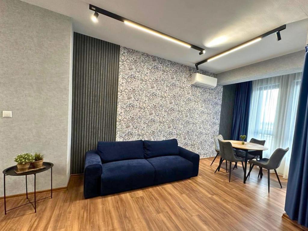 a living room with a blue couch and a table at WEST POINT DELUXE APARTMENT in Plovdiv