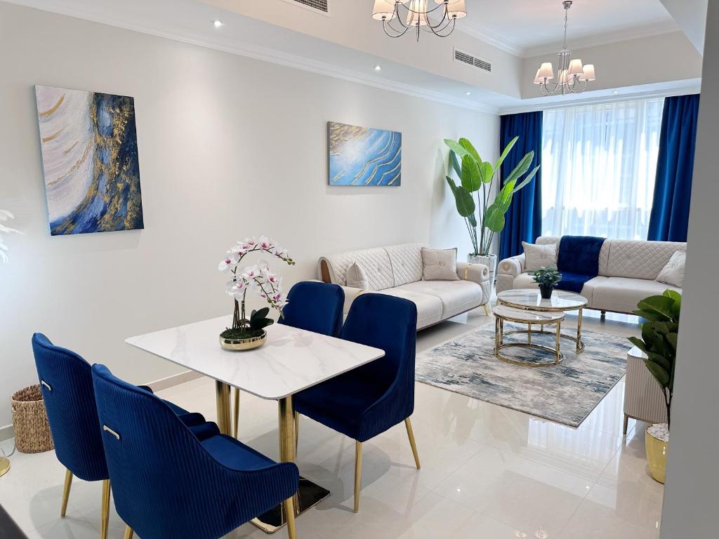 een woonkamer met een witte tafel en blauwe stoelen bij Dunya Tower Luxury and 2 min walk to Dubai Mall and Burj Khalifa in Dubai
