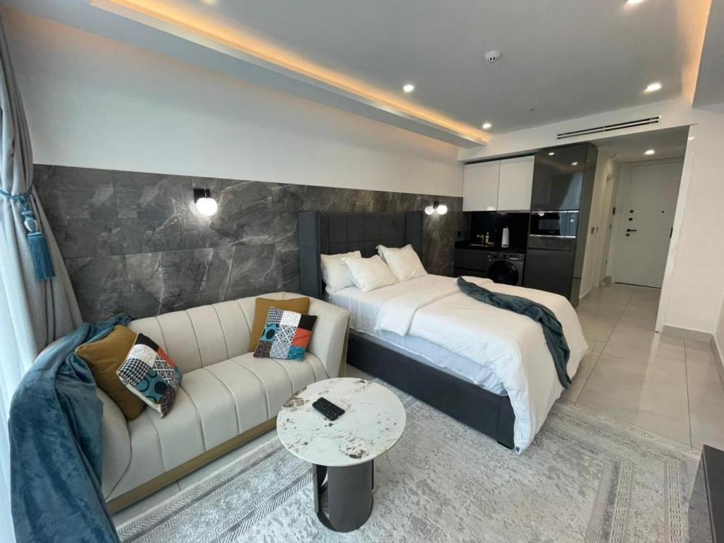 um quarto de hotel com uma cama e um sofá em Kass Towers, Studio Apartment em Acra