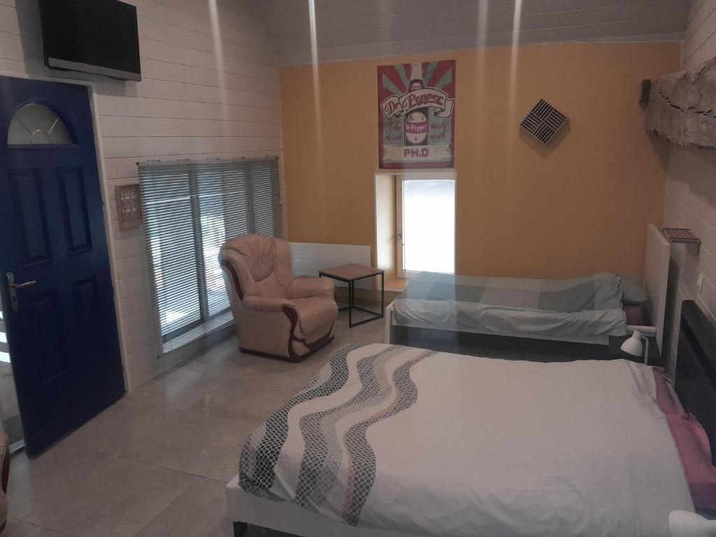 ein Schlafzimmer mit einem Bett und einem Stuhl in einem Zimmer in der Unterkunft chambre plénitude in Condé-sur-Noireau