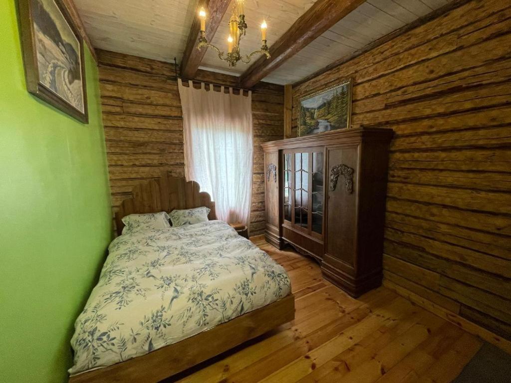 維爾紐斯的住宿－Stebuklas，卧室配有一张床铺,位于带木墙的房间内