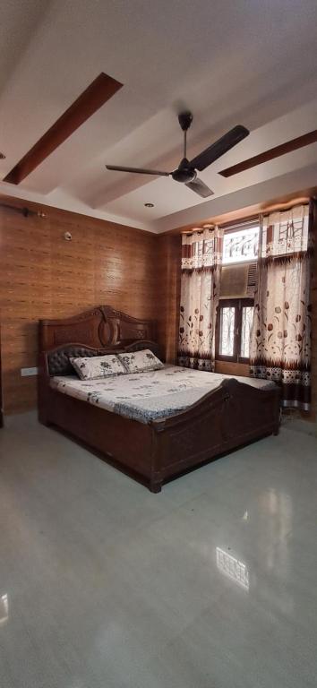 - une chambre avec un grand lit dans une pièce dotée de fenêtres dans l'établissement Cozy Retreat, à Haridwar