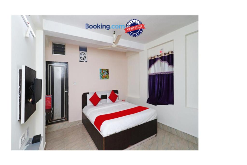 a bedroom with a bed and a television in it at Goroomgo Padoshi Near Sea Beach Puri - Spacious Room 100 Meters From Sea Beach in Puri