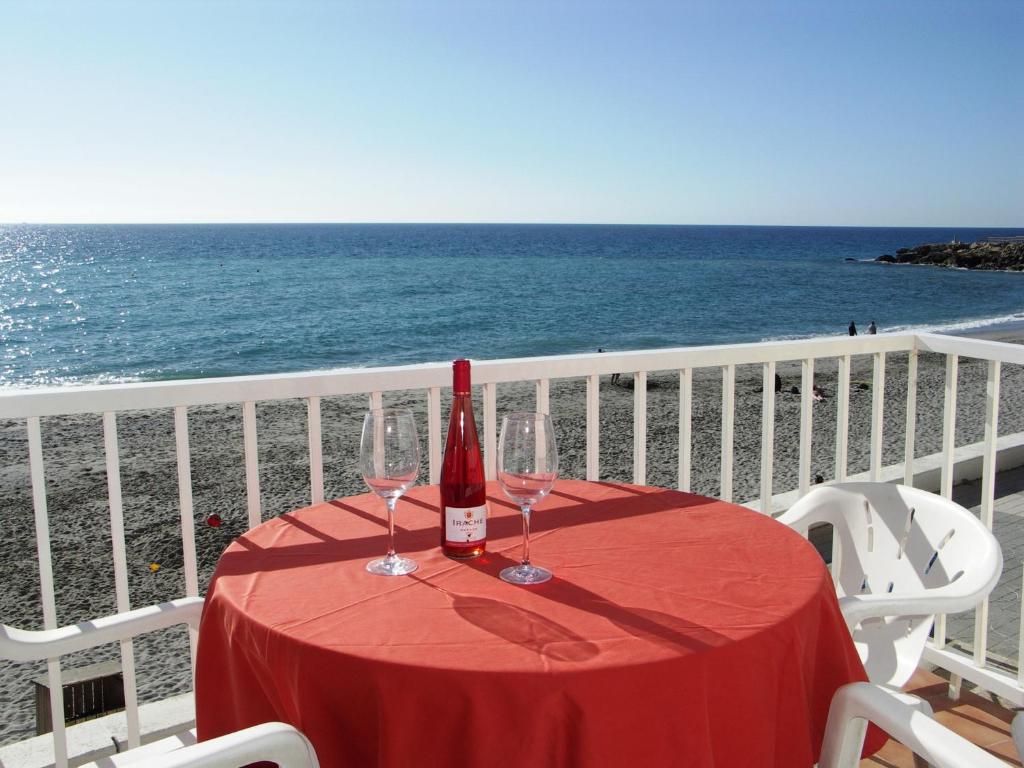 a table with a bottle of wine and glasses on the beach at Apartamentos Lual Torrecilla in Nerja