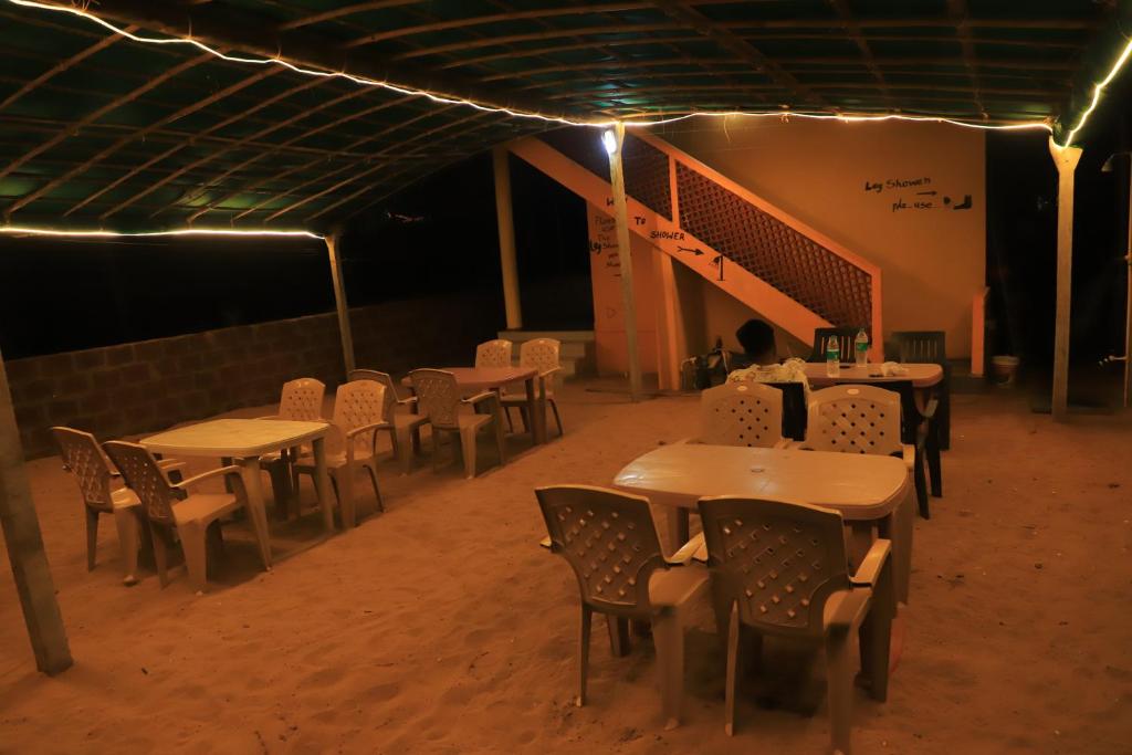 a group of tables and chairs in a room with lights at Ruvi Beach front Ac rooms in Gokarna