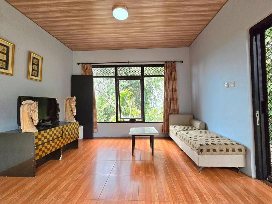 a living room with a couch and a table at Villa Montaview Puncak (Mountain View Cottage) in Gadok 1