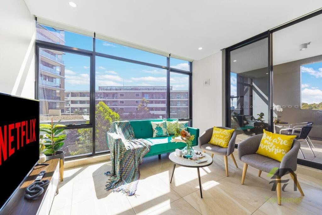 a living room with a couch and chairs and windows at Sunshine 2 Bed home in Olympic Park in Sydney
