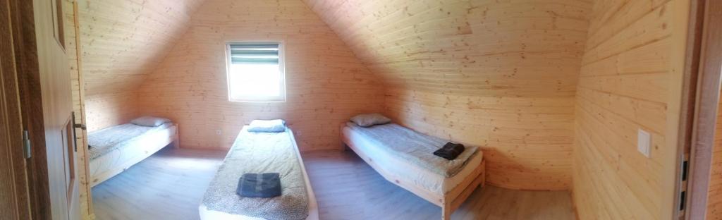 a room with two beds in a wooden room at Lisi Zakątek in Czarna