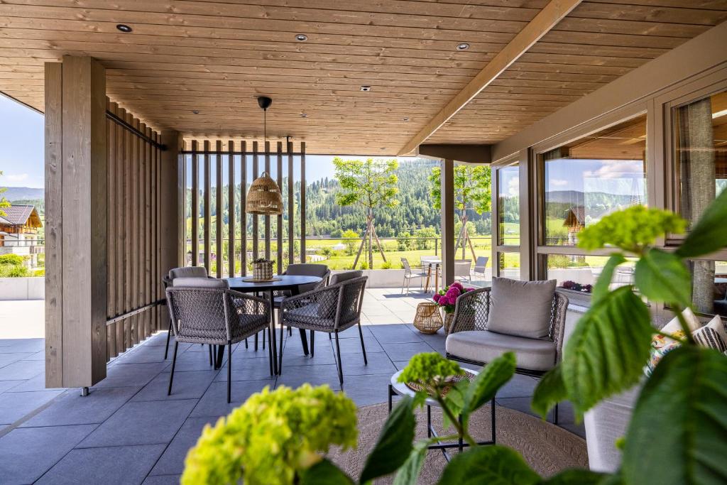 een afgeschermde veranda met een tafel en stoelen bij Aparthotel Jägerheim in Flachau