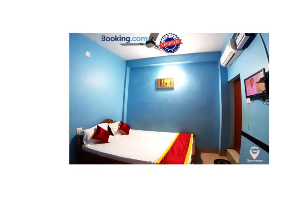 a room with a bed with a blue wall at Hotel Star Lodge Puri in Puri