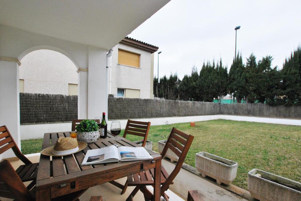 濱海卡夫雷拉的住宿－Ca l'Enric，后院的一张木桌和椅子