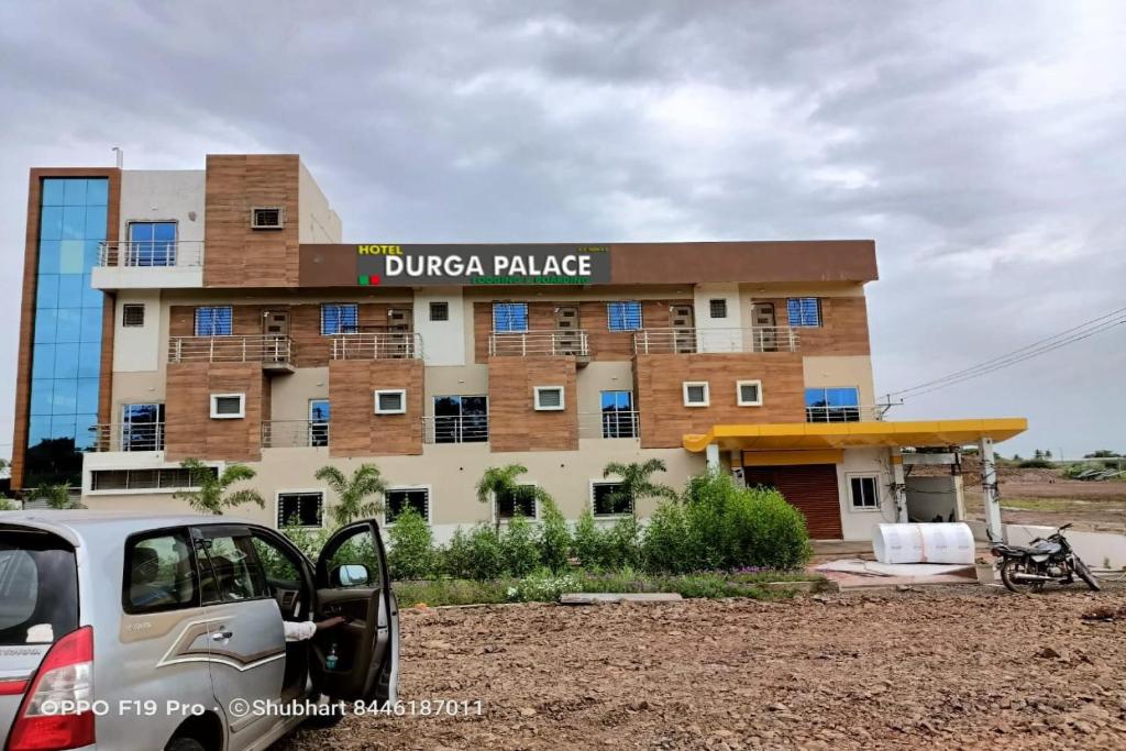 un edificio con un coche aparcado delante de él en SPOT ON Hotel Shree Durga Palace, en Sāngli