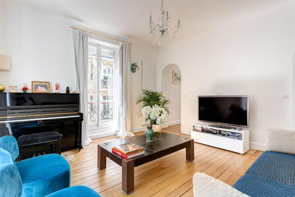 un salon avec une télévision et une table dans l'établissement Elégant 4-room apartment near Arc de Triomphe and Palais des Congrès, à Paris