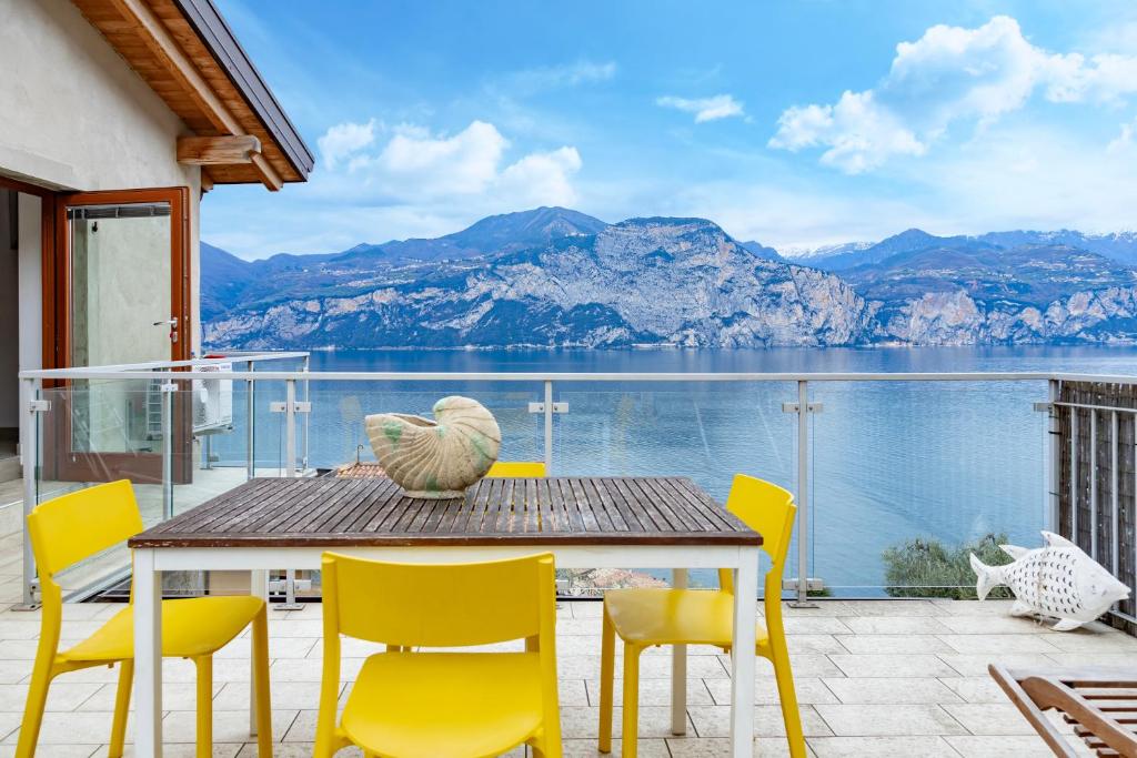 een tafel en stoelen met uitzicht op het water bij Ca de l'Angelon in Brenzone sul Garda