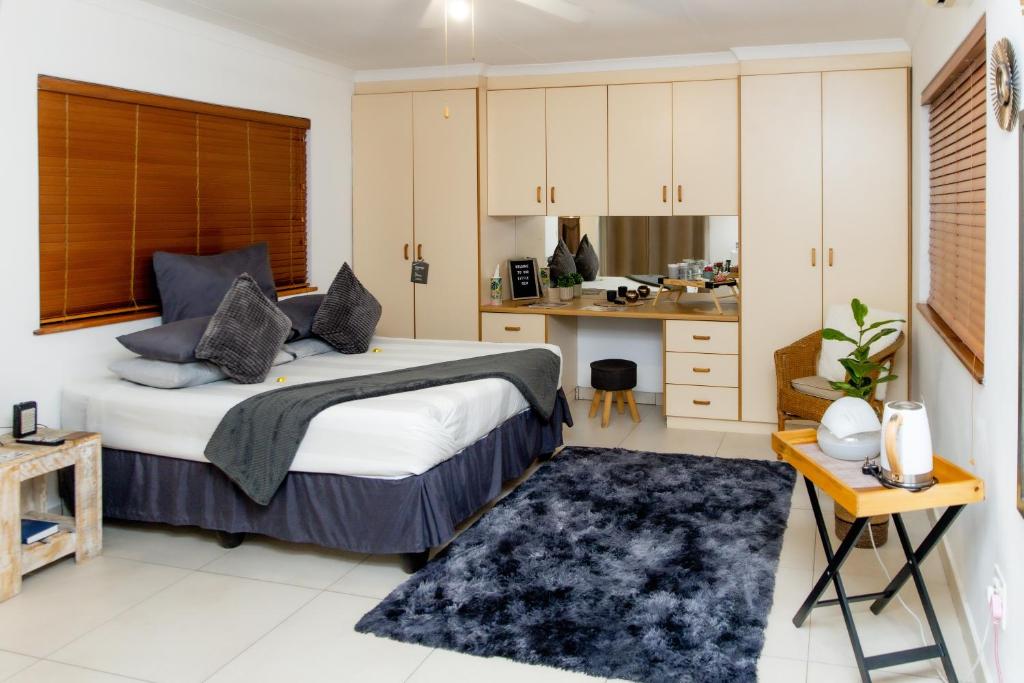 a bedroom with a large bed and a kitchen at The Little Gem in Clanwilliam