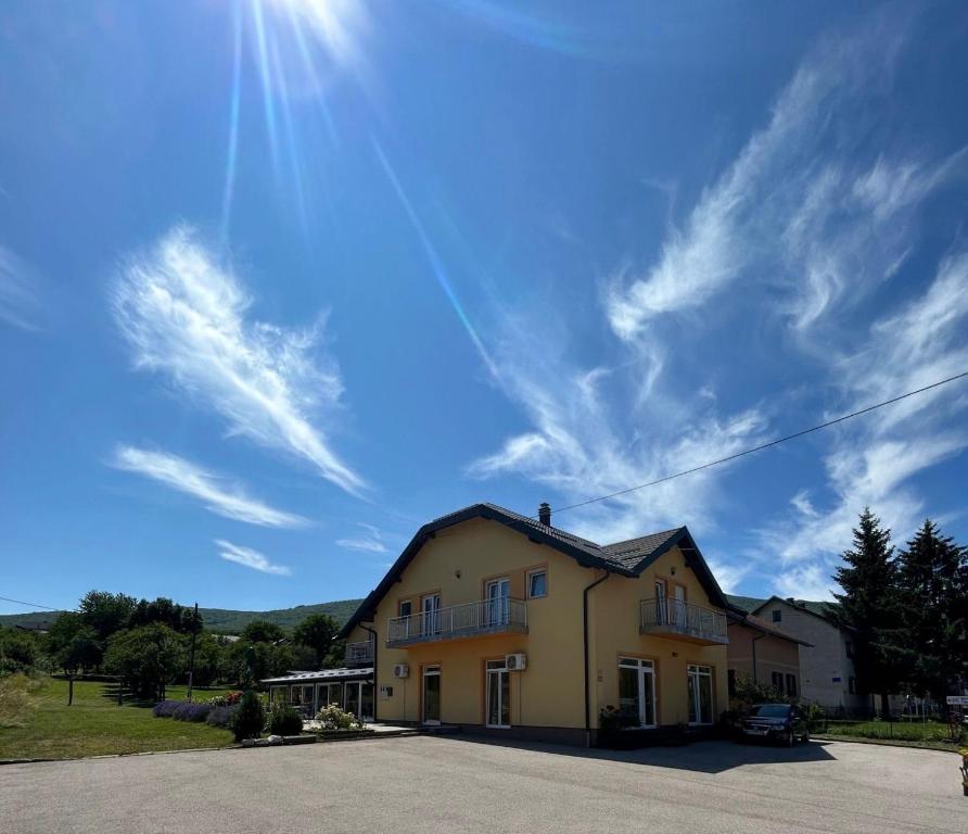 a yellow house with the sun in the sky at Apartment & Rooms Thomas in Korenica