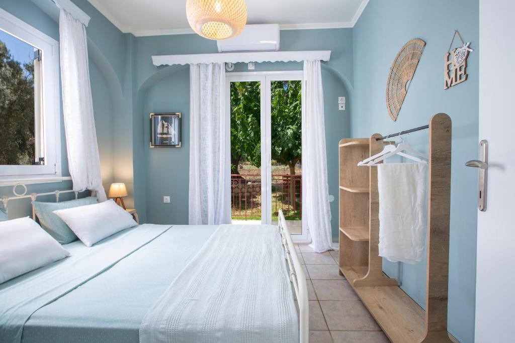 a blue bedroom with a bed and a window at Levanda Cozy Apartments in Lefkada